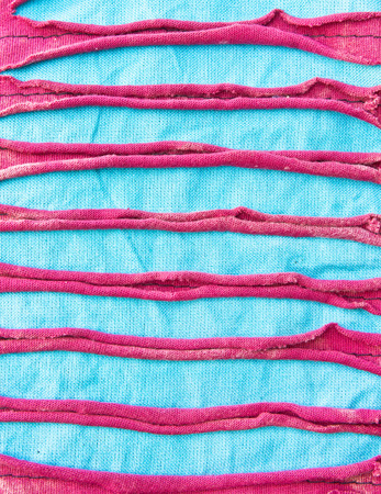 Close up of part of a blue and burgundy textile surface