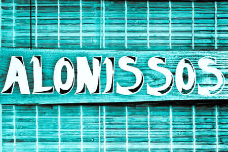 A sign on a wood surface with the name of Alonissos