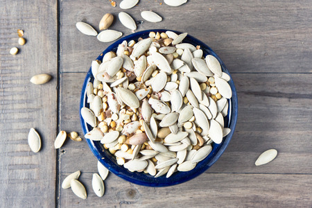 Mixed salted nuts and seeds on a wooden tableの写真素材