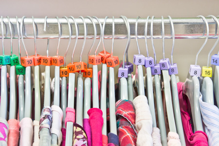 Casual tops on hangers in a charity storeの写真素材