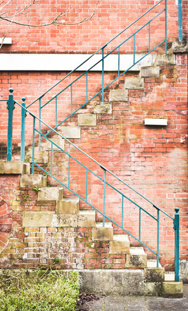 External fire escape stairs on a red brick building in the UKの写真素材
