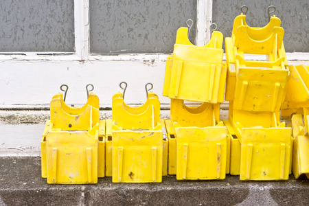 Yellow pastic clips used for scaffolding, on an exterior window ledgeの写真素材