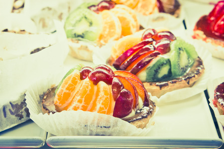 Freshly baked fruit tarts in a storeの写真素材