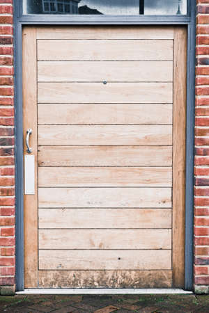 A modern wooden door in a brick buildingの写真素材