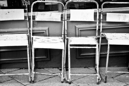 Colorful rusty metal chairs outside a storeの写真素材