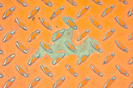 Orange industrial metallic background with an area of exposed metalの写真素材