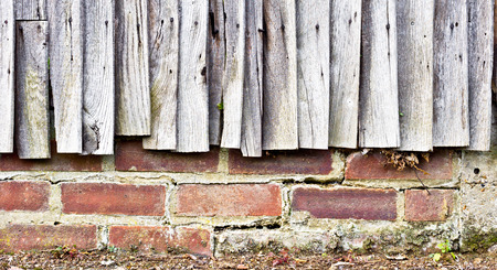 Weathered fence panels against a brick wallの写真素材