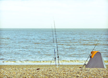 Fishing rods and a tent on a UK beachの写真素材
