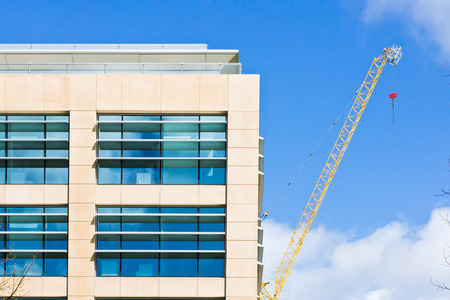 A modern building in the UK with a yellow crane in the background
