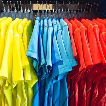 Colorful men's t shirts on a clothing rackの写真素材