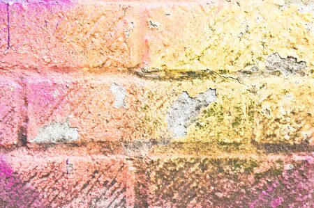 Peeling paint on a weathered brick wall