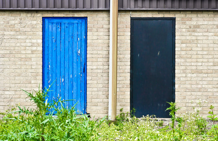 Blue and grey wooden doors in the wall of a buildingの写真素材