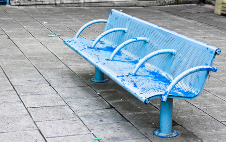 A weathered metal bench in an urban setting