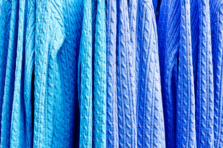 Blue jumpers hanging as a background imageの写真素材