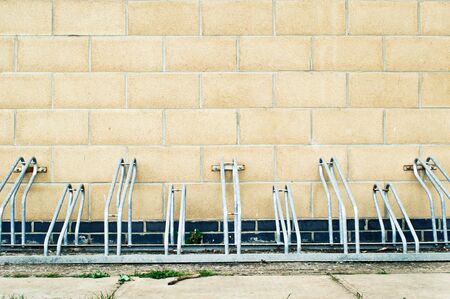 Metal racks for parking bicycles against a modern brick wallの写真素材