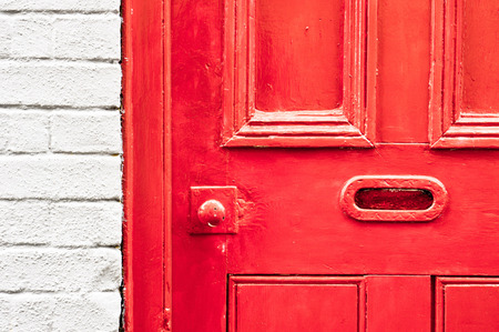 A vibrant red painted wooden front door with a letterboxの写真素材