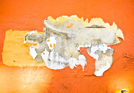 Peeling orange paint on a stone wall, as a backgroundの写真素材