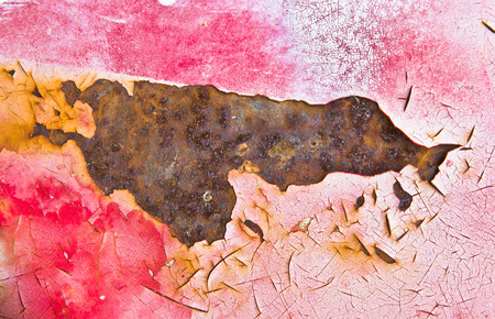 Red paint cracked with underlying rusted metal