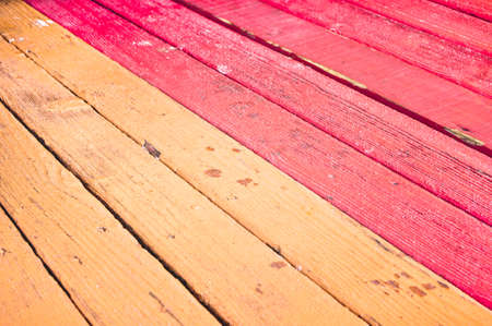 Red and orange weathered wooden panels with selective focusの写真素材
