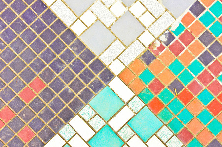 Part of a patterned tiled surface which is weathered and dustyの写真素材