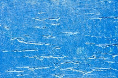 Cracked paint on a blue painted wooden surface, as a backgroundの写真素材