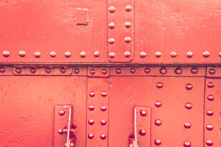 A studded red metallic surface as a backgroundの写真素材