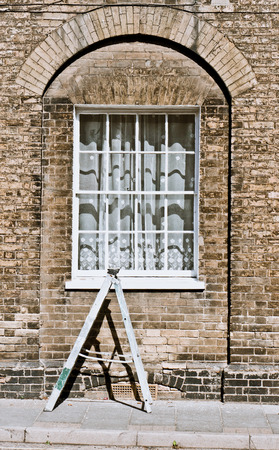 A small ladder in front of the window of a town house in Englandの写真素材