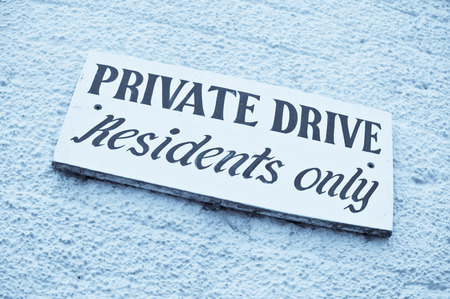 A sign for a private drive on a brick wall, in blue monochromeの写真素材