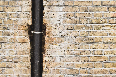 Part of a black plastic drainpipe in a brick wallの写真素材
