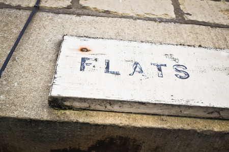 A wooden sign on an apartment building in the UKの写真素材