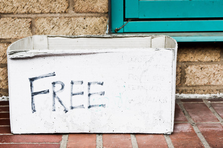 A white cardboard box whioch has been emptied of free unwanted goods outisde a houseの写真素材