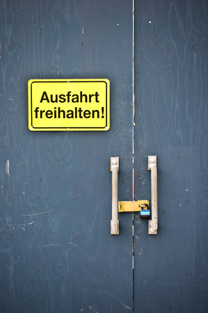 A yellow sign on a  door in German statuing to keep clear of the exit