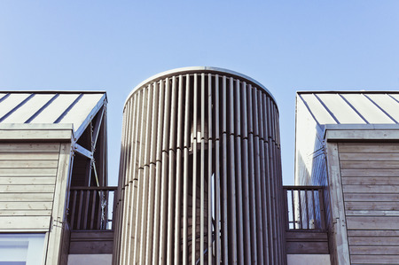 Part of a modern wooden building against a blue sky