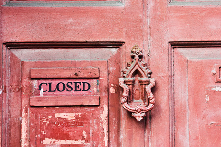 Part of a red wooden front door with an old fashioned knockerの写真素材