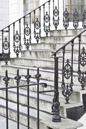 Part of a set of stone steps with metal railings at the entrance to a houseの写真素材