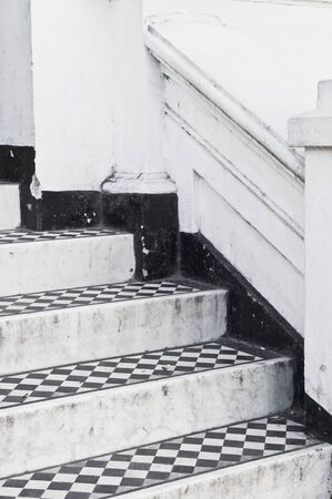 Steps at the entrance to a house with decorative black and white tiles