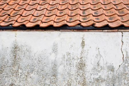 Part of the exterior of an old building with terracotta roof tiles