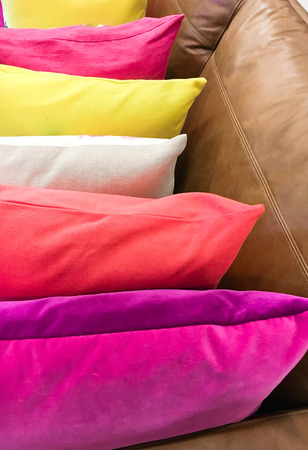 Brightly colored cushions on a leather sofa