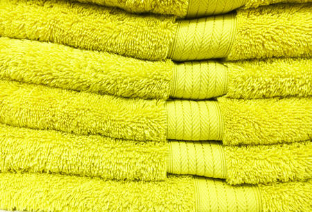 A stack of yellow towels as a backgroundの写真素材