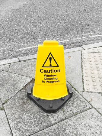 A window cleaning warning notice on a public walkway