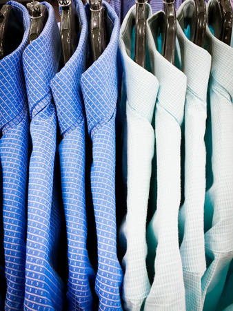 Smart men's shirts hanging on a rackの写真素材