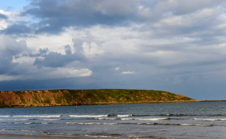 Seascape of the cliffs near Filey in the United Kingdom . Featuring waves in the foreground.の写真素材