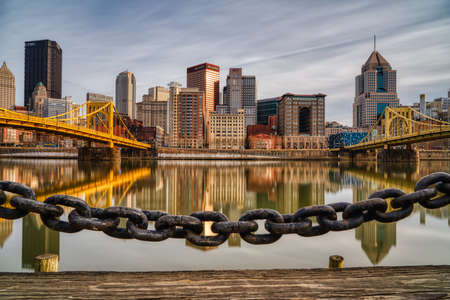 Allegheny River, downtown Pittsburgh, Roberto Clemente and Andy Warhol Bridges and sun is about to set on a cloudy day. Shot in long exposure forming a smooth milky reflective surface.の写真素材