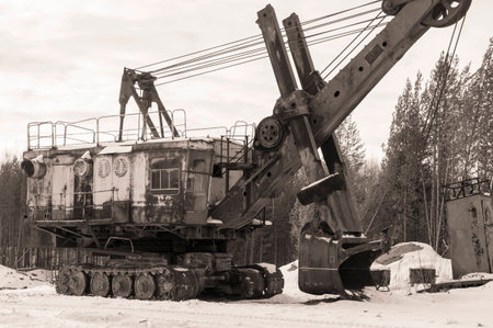 Black and white photo of an old excavator in the winterの写真素材