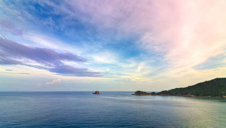 Small island and colorful sky in sunsetの写真素材