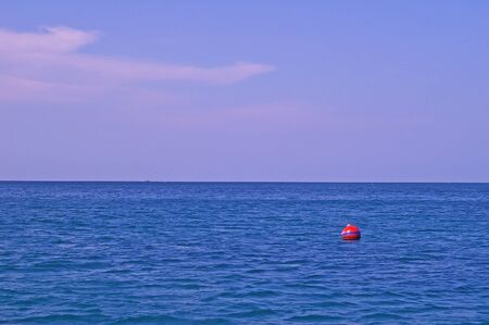 blue sea and sky with a small red seamarkの写真素材