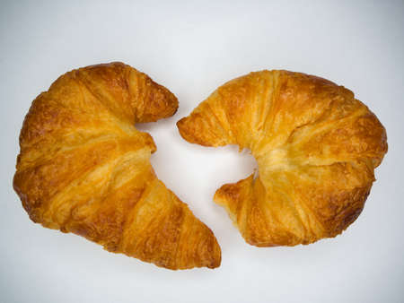Two Baked buttery croissants on a white backgroundの写真素材