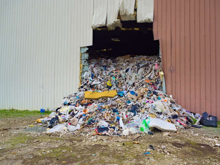Rubbish spilling out of the warehouse with a huge hole in the wall. Stink rubbish