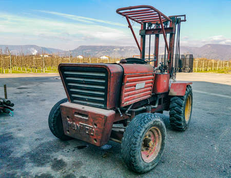 A very old electric wheelchair outside of a manufacturing factoryの写真素材