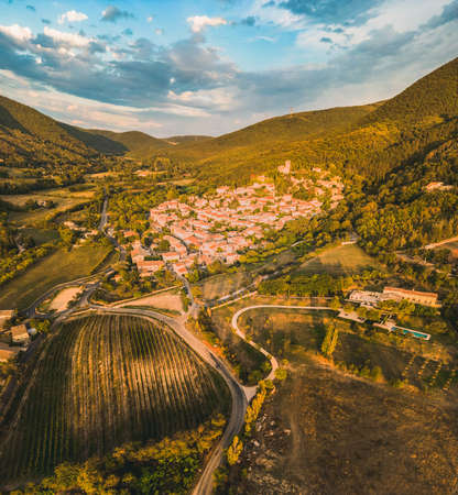 Panoramic drone view of one of the most beautiful French towns in southern France - Mirmande. Old historic town. Sunset over the surrounding mountains.の素材 [FY310191389754]